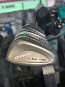 The image displays a set of used Mizuno GM100 golf irons. These are mens right-handed clubs designed for game improvement and feature a T.L. Flow System and cavity back design. 