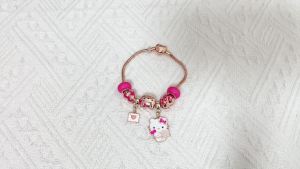 Sanrio | Vòng Tay Charm Tự Làm Hello Kitty Dành Cho Cả Nam Và Nữ Chất Liệu Hợp Kim Kẽm Dây Xích Vàng Hồng Có Thể Điều Chỉnh Kèm Nhiều Charm Hình Kitty Và Hạt Men Màu Hồng.