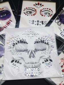 สติ๊กเกอร์หน้าเพชรสําหรับเทศกาลดนตรีอิเล็กทรอนิกส์พร้อมดีไซน์ศิลปะสีดําและสีสันสดใส เหมาะสําหรับแต่งหน้าวันฮาโลวีนและเครื่องมือเสริมความงาม