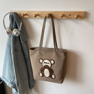 กระเป๋าถือทรงถุงผ้าลายหมีการ์ตูนปักลายสุดน่ารักสำหรับผู้หญิง กระเป๋าสะพายไหล่ข้างเดียวสำหรับเดินทาง ความจุขนาดใหญ่ กระเป๋าถือแบบลำลอง
