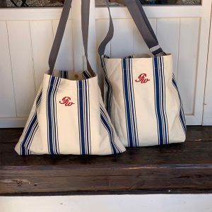 2024 สไตล์เกาหลี กระเป๋าผ้าแคนวาสความจุขนาดใหญ่ ผู้หญิง กระเป๋าสะพายข้างปัก ลายทาง กระเป๋าทรงถัง ทันสมัย กระเป๋าสะพาย