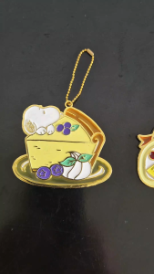 Snoopy and a slice of cheese cake with blueberries hanging enamel decoration