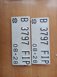 PLAT NOMOR BAUT TANAM SEPASANG DEPAN BELAKANG WARNA PUTIH DAN HITAM ADA LOGO TIMBUL