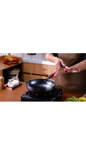 TaroYaki Frying pan with wooden handle non-stick surface for cooking on portable stove in kitchen setting.