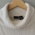 Sweater turtleneck oversize putih. 