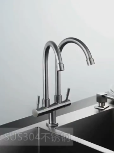 Stainless steel dual faucet with curved spouts and lever handles for kitchen sink.