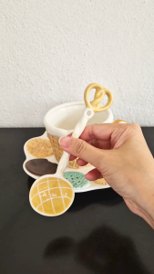 Ceramic polo bun spoon with pretzel-shaped end to the handle