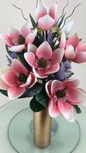 กำลังไหลเมื่อการเสริมจมูก ดอกไม้ประดิษฐ์ และสามารถใช้งานได้ดี ดอกแมกโนเลียจัดในแจกันแก้วสีทอง