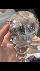 大爆彩阿塞白七彩水晶 爆彩白水晶球{Clear Quartz Sphere with Rainbow Inclusions }  这一块非常通透的原矿并不多、非常之少量：  1️⃣ 原矿要够纯净 白水晶本身是石英，但天然白水晶常常含有： • 棉絮（冰裂、云雾感） • 气泡、水线、矿纹 • 内含其他矿物或裂纹  👉 只有原矿中杂质极少、裂少，才容易做出“通透”效果。  当🈶一块高品原矿料子时： 2️⃣ 原矿要够大 & 切磨精准 • 大水晶球如果纯净，视觉上会更通透、饱满。 • 球形打磨精度高，光线通过表