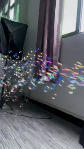Fully automatic stage bubble machine for outdoor parties - enhancing atmosphere with lighting. Portable electric bubble blowing toy for children