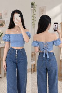 Blue off-shoulder crop top with puff sleeves and lace-up back paired with high-waisted wide-leg jeans.