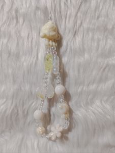 Beaded phone strap with assorted charm design and textured beads.