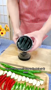 Cối xay tỏi bằng thép không gỉ với tay cầm đen và lưỡi dao sắc bén.