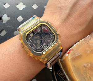 Đồng hồ Casio G-Shock trong suốt màu vàng với màn hình kỹ thuật số và dây đeo màu nâu.