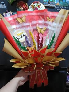Ready made empty money bouquet with Fairy Lights. Red and gold wrapping butterfly decorations "Happy Birthday" tag festive scene.