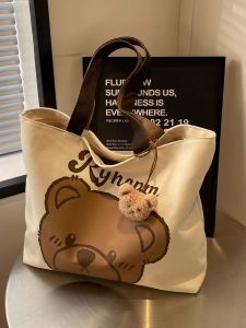 กระเป๋าผ้าใบทรงโตสำหรับใส่ของใช้ประจำวัน ความจุขนาดใหญ่ กระเป๋าสะพายไหล่ข้างเดียวลายหมีการ์ตูนสำหรับนักเรียน กระเป๋าสะพายข้างสำหรับเดินทาง