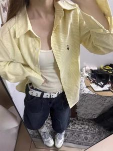 เสื้อเชิ้ตแขนยาวลายทางสีเหลืองสำหรับผู้หญิงในช่วงฤดูร้อนปี 2024 ทรงหลวมสบาย ๆ ป้องกันแสงแดด เสื้อเชิ้ตผู้หญิงสไตล์เกาหลี