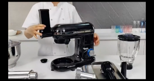 Black multi-function kitchen appliance with stainless steel bowl meat grinder blender and attachments for mixing and blending. Suitable for preparing smoothies ground meat and baked goods.