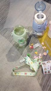 Bình nước 650ml họa tiết hình gấu dâu dễ thương cho các bé đi học có dây đeo chéo sticker 2D 3D và ống hút