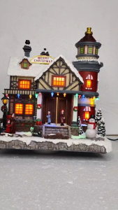 ONELINE #FC709 hand-painted resin Christmas village house featuring warm LED lights a "Merry Christmas" sign a side tower and miniature figurines