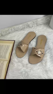 Black patent leather slide sandals with silver buckles and white stitching.