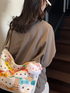 MOUSSON  กระเป๋าสะพายไหล่กระเป๋าสะพายข้างกระเป๋าผ้าใบกระเป๋าผ้าใบการ์ตูน HelloKitty ความจุขนาดใหญ่กระเป๋าโท้ทสะพายไหล่นักเรียนกระเป๋าสะพายข้างลำลองแมทช์ลุคง่าย