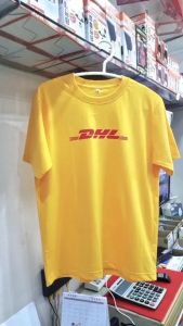 เสื้อยืดยูนิฟอร์ม และหมวกแก๊ป "เห็นเหลืองแบบนี้ รู้เลย DHL! แต่วันนี้ไม่ใช่แค่ส่งพัสดุ…เสื้อยืดเค้าก็เท่ด้วย