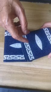 กระเป๋าหนังปลากระเบนทรงตั้งมีแถบลายจีนข้างบนและข้างล่างเต็มใบมีมุขขาวเด่นๆ