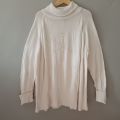 Sweater turtleneck oversize putih. 