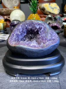 qiandaizi 💰钱袋💯天然紫晶钱袋子 左右两侧圆角像脸颊😊绿皮幽灵边 异象晶体 先结晶紫晶 柱角是透亮白水晶 + 🆓特制实木底座 foc stand base   钱袋子高raw height: 9.5cm  宽raw width: 13cm x 10cm  净重raw weight: 1.05kg 含底座高total height: 13cm  底座宽total width: 16cm x 12cm  总重total weight: 1.35kg  📍Johor Bahru 区可自行取货