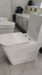 White ceramic toilet with closed lid modern design soft closing seat and cover. Dimensions L77cm x D66cm x W36cm.