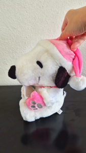 Snoopy with a pink hat & pink gloves holding a letter with a ribbon & a paw print