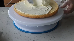 White rotating cake turntable with blue non-slip base.