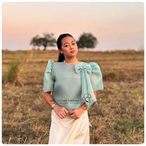 Modern Filipiniana kimona with detachable (Big)ribbonfeaturing puffed sleeves set in a field at sunset.
