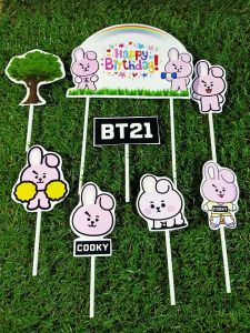 Cake topper BT21 Cooky happy birthday\\n\\n Apa itu Cake Topper?\\n\\n Definisi Cake Topper\\n\\nCake topper adalah hiasan atau dekorasi yang diletakkan di atas kue, biasanya digunakan untuk menandai momen spesial seperti pesta ulang tahun, pernikahan, atau acara-acara lainnya. Cake topper bisa berbentuk karakter, bunga, atau hiasan lainnya sesuai tema dan kebutuhan.\\n\\n Fungsi Cake Topper dalam Dekorasi Kue\\n\\nCake topper memiliki beberapa fungsi penting dalam dekorasi kue, di antaranya:\\n\\n- Menambah estetika dan daya tarik kue\\n- Menunjukkan tema atau momen spesial\\n- Sebagai hiasan yang bisa disimpan sebagai kenang-kenangan\\n\\n Cara Memilih Cake Topper yang Tepat\\n\\nUntuk mendapatkan cake topper yang tepat, Anda bisa mempertimbangkan beberapa hal berikut:\\n\\n Aksesoris Cake Topper Karakter\\n\\nPilihlah cake topper karakter yang sesuai dengan tema pesta dan minat orang yang berulang tahun. Misalnya, jika orang yang berulang tahun menyukai karakter BT21 Cooky, maka cake topper BT21 Cooky bisa menjadi pilihan yang tepat.\\n\\n Desain Cake Topper Karakter\\n\\nPerhatikan desain cake topper karakter yang akan Anda pilih. Pastikan desain tersebut menarik dan sesuai dengan tema pesta. Misalnya, cake topper BT21 Cooky yang memiliki desain unik dan menarik bisa menjadi pilihan yang baik.\\n\\n Menggunakan Cake Topper BT21 Cooky untuk Pesta Ulang Tahun\\n\\nUntuk menggunakan cake topper BT21 Cooky dalam pesta ulang tahun, berikut beberapa tips yang bisa Anda ikuti:\\n\\n Tips Memasang Cake Topper pada Kue\\n\\n1. Pastikan kue sudah dingin sebelum memasang cake topper.\\n2. Letakkan cake topper di atas kue secara rata dan pastikan posisi sudah tepat.\\n3. Jika perlu, gunakan perekat yang aman untuk makanan agar cake topper tetap berada di tempatnya.\\n\\n Cara Menyimpan Cake Topper Setelah Digunakan\\n\\nSetelah digunakan, cake topper bisa disimpan sebagai kenang-kenangan. Untuk menjaga kebersihan dan keawetan, simpanlah cake topper dalam kotak atau wadah yang aman dan kering.\\n\\n Kesimpulan\\n\\nCake topper BT21 Cooky adalah pilihan yang tepat untuk dekorasi kue dalam pesta ulang tahun. Dengan mempertimbangkan beberapa hal seperti aksesoris karakter dan desain, Anda bisa mendapatkan cake topper yang menarik dan sesuai dengan tema pesta. Selamat merayakan momen spesial dengan cake topper BT21 Cooky!\n}