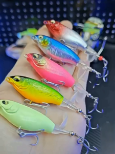 Water surface tractor fishing lures with three-point hooks in various colors for freshwater and saltwater fishing.
