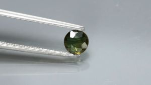 0.60 ct พลอยแท้ พลอยตลก 2 สี เผาbe สีเขียวอมเหลือง ทรงกลม