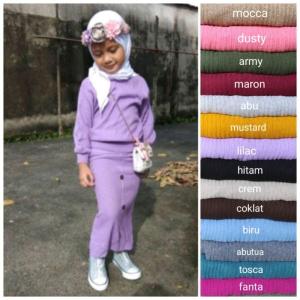 Setelan rajut anak rok kancing berwarna ungu dengan detail kancing di bagian depan. Cocok untuk anak-anak dengan gaya kasual.