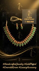 Gold necklace with green gemstones and matching earrings.