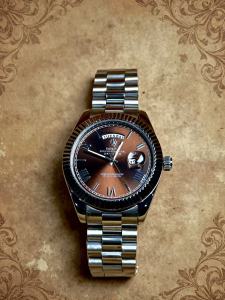The mens luxury watch exudes a refined yet avant-garde vintage charm featuring a 41mm case a dual-date display function a silver-toned case and a distinctive coffee-colored dial that creates a striking contrast. It emanates a touch of aristocratic no