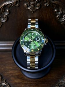 A golden mens watch crafted with a solid golden case and bracelet. The classic green dial is equipped with a Chromalight illumination system. Vintage luxurious modern and water-resistant it is suitable for both business and casual settings.