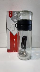 Glass Tea Infuser Cup for Tea Separation with Black Lid and Strap Pouring Tea into Glass Jar.