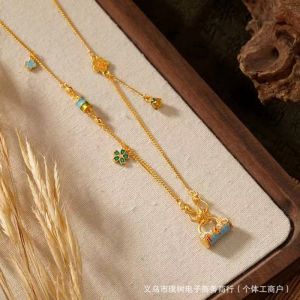 A floral-patterned safety lock pendant necklace with gold-colored enamel similar to those found in jewelry stores complete with a tassel. A fashionable necklace for women.