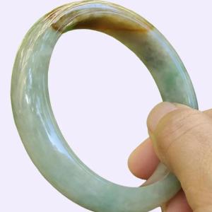 53.5 mm Light Green with Brown Patch Quality Burma Natural Type A Jadeite Jade crafted as Peace Bangle certificate weighs 50.76 grams Width: 13 mm Thickness: 7.6 mm (bangle16)