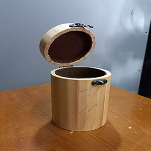 hộp gỗ thông tròn đựng bút viết linh tinh để trên bàn làm việc.