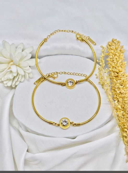 gelang hitam di tangan kiri dengan simbol misterius