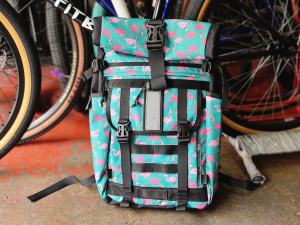 Exonomad Flamingo Backpack Roll Top 24 liters capacity Sports Bag with teal and pink flamingo pattern black straps and buckles