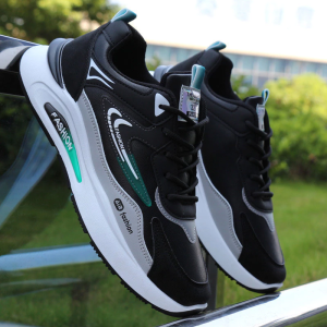 Black and gray sneakers with teal accents. Fashionable design. Suitable for casual wear. Displayed on a dark surface.