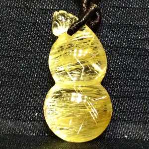 A pure natural golden hair crystal pendant shining with golden light with a transparent crystal structure and an extremely beautiful cats eye effect. Wearing it can attract wealth ward off evil spirits ensure safety and protect against bad people.