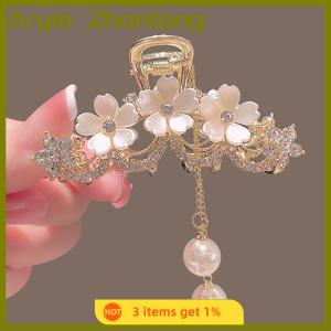 Aryio คลิปหนีบผมโลหะประดับด้วยเพชรที่หุ้มด้วยดอกมะลิและดอกไม้ประดับด้วยพู่ที่หนีบผมของผู้หญิงที่ด้านหลังศีรษะ